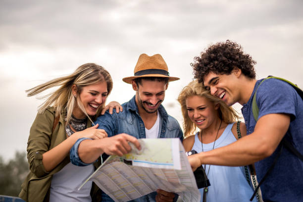 group of tourists searching for places on their map outdoors.
