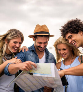 group of tourists searching for places on their map outdoors.